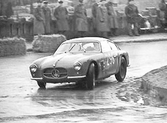 Silberne Maserati Rennberlinetta auf regennasser Strecke, historische Schwarzweissaufnahme